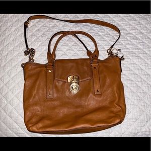 Michael Kors brown purse with strap and handle.